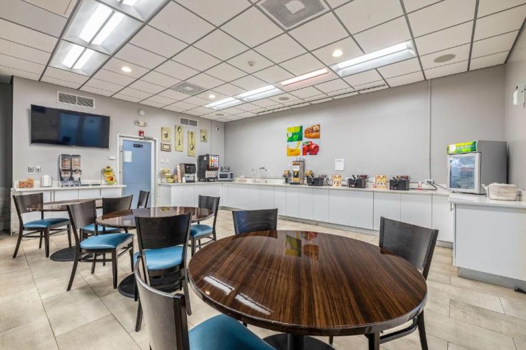 Sala de desayuno buffet del Quality Inn Tampa Brandon con mesas redondas y barra de autoservicio
