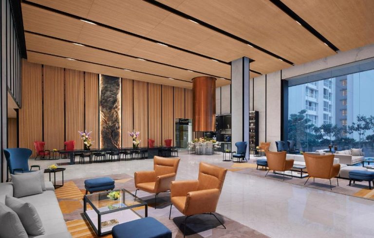 Elegante lobby lounge del Taj The Trees Mumbai con sillones de cuero y grandes ventanales