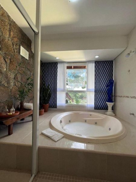 Jacuzzi redondo empotrado en suite de lujo con ventana y pared decorativa azul en CasaIvan