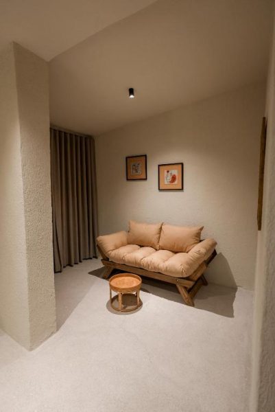 Rincón de relax con sofá nórdico y mesa auxiliar de ratán en Bitez Corner Boutique Hotel