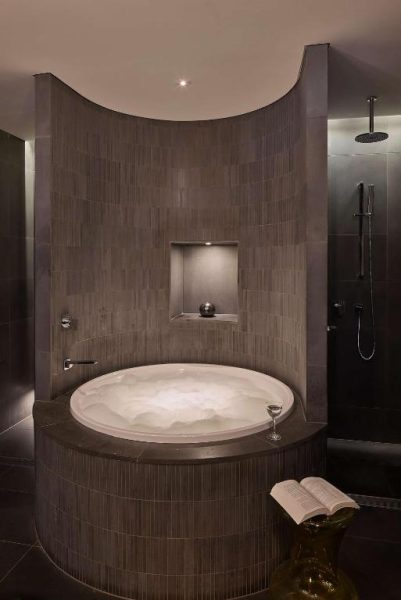Lujosa bañera circular de hidromasaje con espuma en el spa del hotel QT Sydney