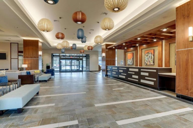 Amplio lobby con recepción y lámparas decorativas del Drury Plaza Hotel Orlando Disney Springs Area