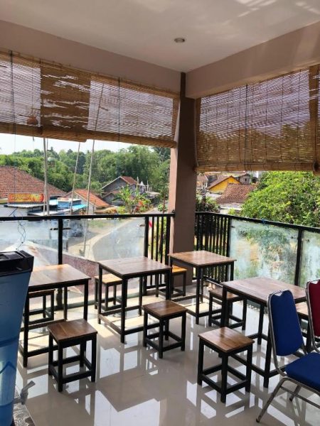 Terraza restaurante con mesas de madera y vistas al pueblo en L'Javas Villas
