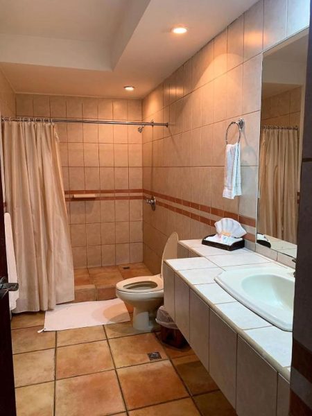Baño completo con ducha, lavabo y sanitario del Hotel Casa del Sol con azulejos beige