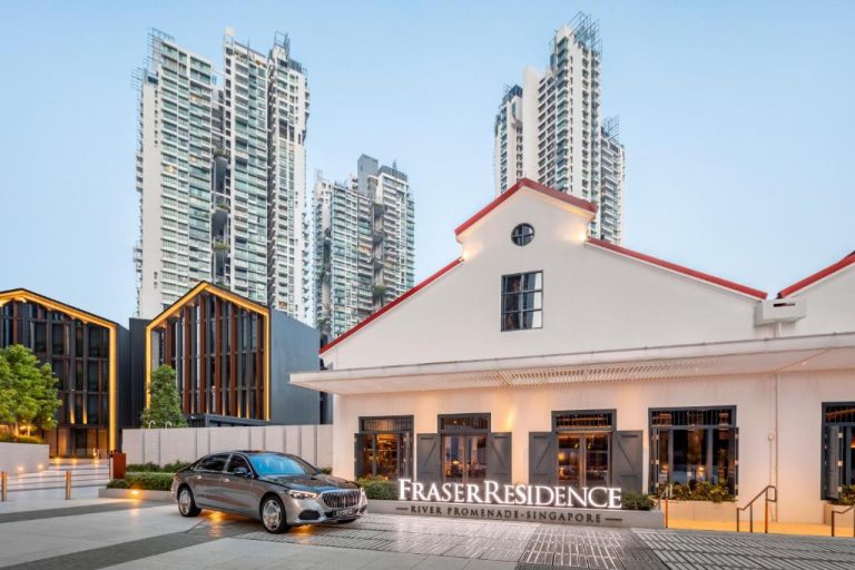 Fachada exterior del Fraser Residence River Promenade Singapur con limusina y rascacielos al fondo