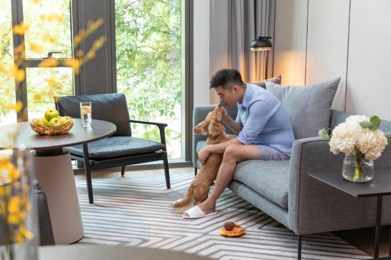 Huésped disfrutando con su perro en la sala de estar del Fraser Residence River Promenade Singapur