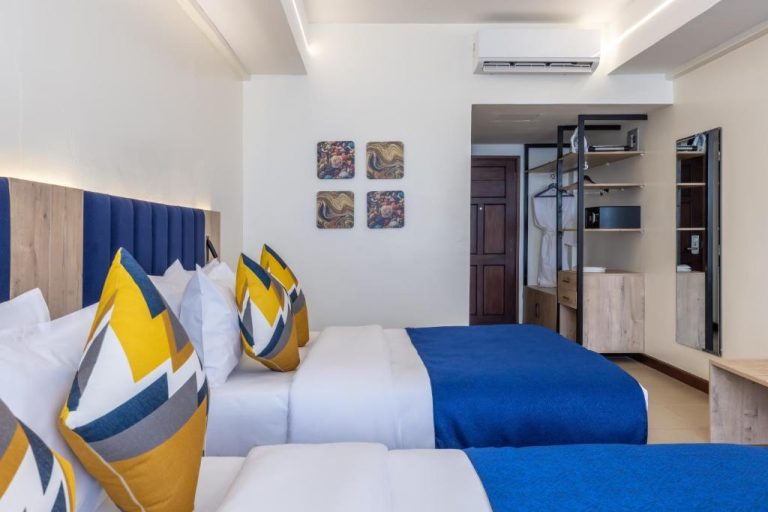 Habitación doble con dos camas y decoración en azul y amarillo en Premium Inn Mombasa City