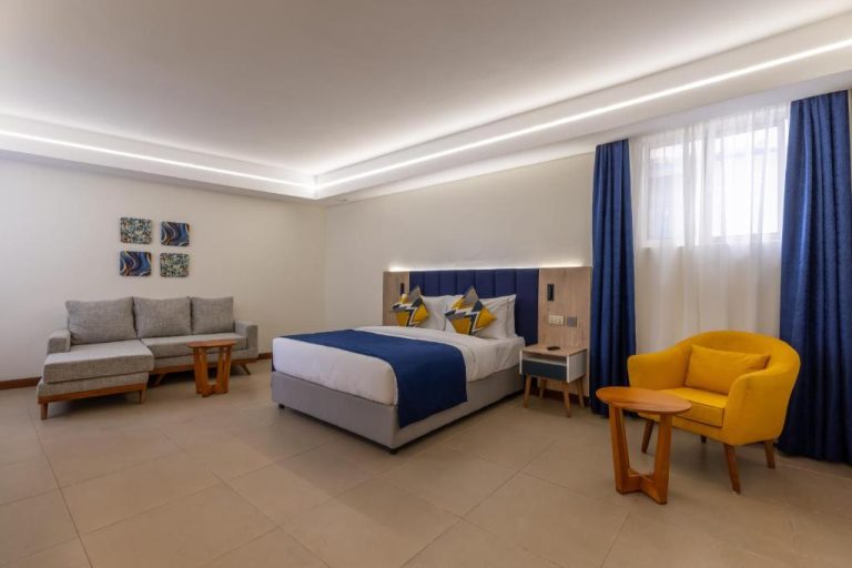 Habitación suite deluxe con cama doble y decoración en azul y amarillo en Premium Inn Mombasa City