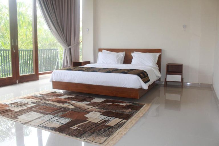 Habitación doble con cama de madera y balcón con vistas al jardín en L'Javas Villas