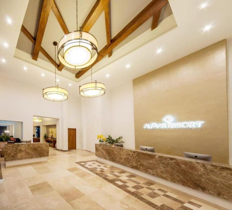Recepción principal del Almar Resort con lujoso lobby, vigas de madera y elegantes lámparas colgantes