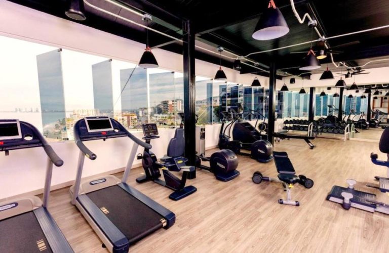Gimnasio moderno con vistas al mar en Grant's Studio at Mantamar Tower, equipado con cintas y bicicletas