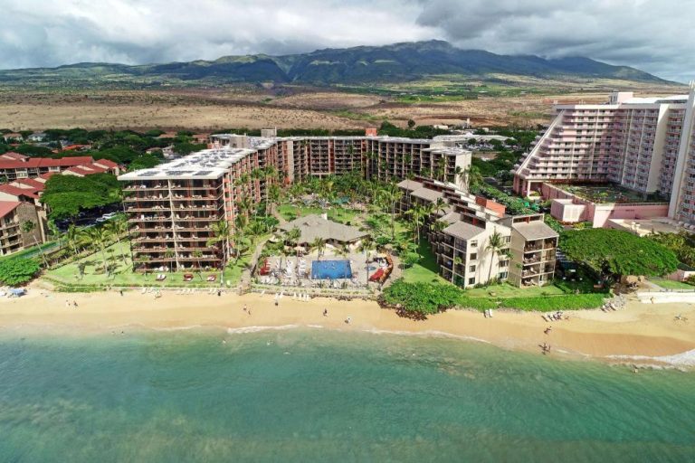 Vista aérea del Aston Kaanapali Shores con piscina exterior y playa de arena en Maui, Hawái