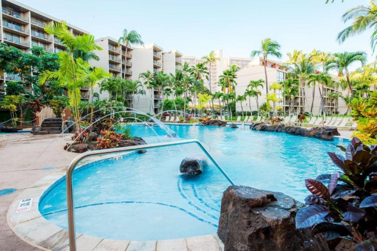 Piscina exterior con fuentes y rocas volcánicas rodeada de palmeras en el Aston Kaanapali Shores Hawaii