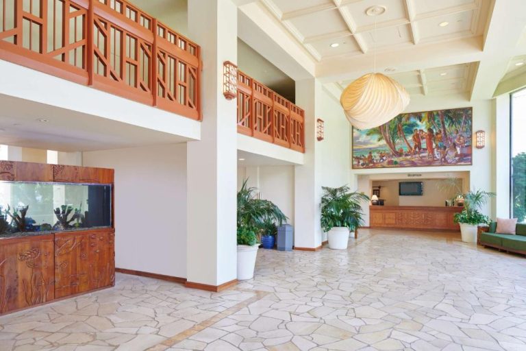 Amplio lobby con recepción, acuario y mural hawaiano del Aston Kaanapali Shores en Maui