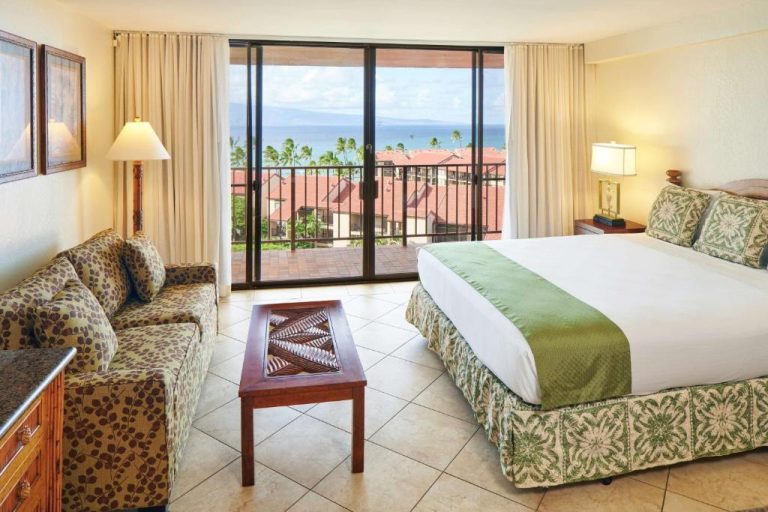 Habitación con cama doble y vista al océano desde balcón en Aston Kaanapali Shores Maui