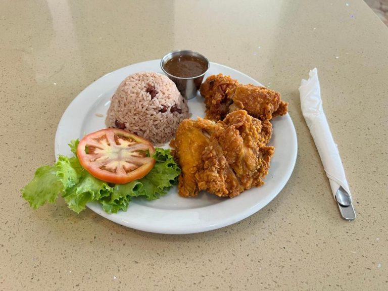Plato de pollo frito crujiente con arroz con frijoles y ensalada fresca en el restaurante de Toby's Resort