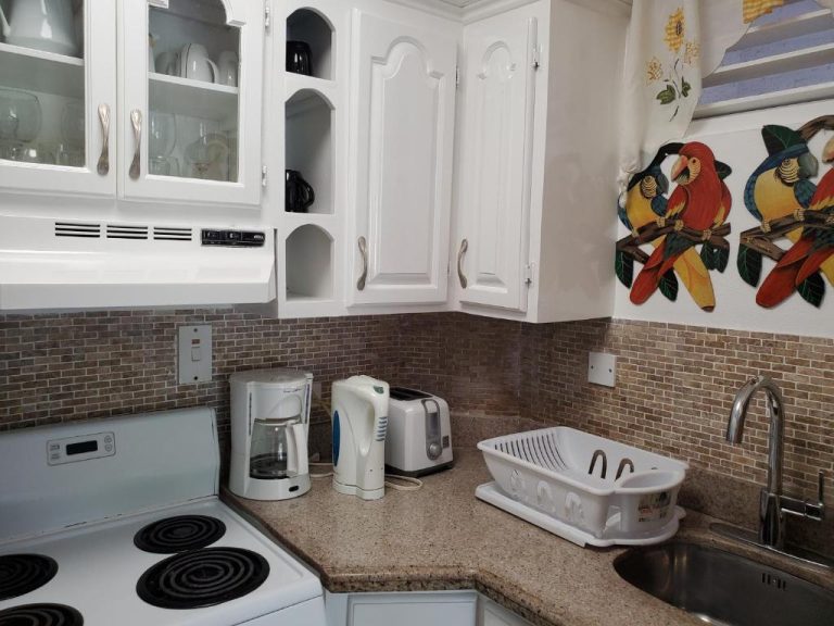 Cocina totalmente equipada con electrodomésticos blancos y decoración tropical en Sandcastles Resort Ocho Rios