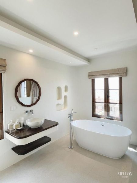 Baño de suite con bañera exenta y lavabo sobre encimera en Mellon Oasis Phu Quoc