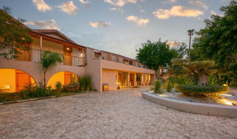 Fachada exterior iluminada del Day One Beach Resort & SPA Adult Only con jardines tropicales y acceso principal