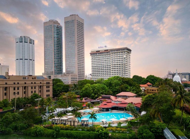 Vista aérea de la piscina exterior y jardines del Hilton Colombo Hotel con el skyline de la ciudad