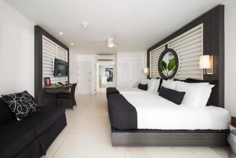 Habitación deluxe en blanco y negro con cama king size y decoración moderna en S Hotel Montego Bay