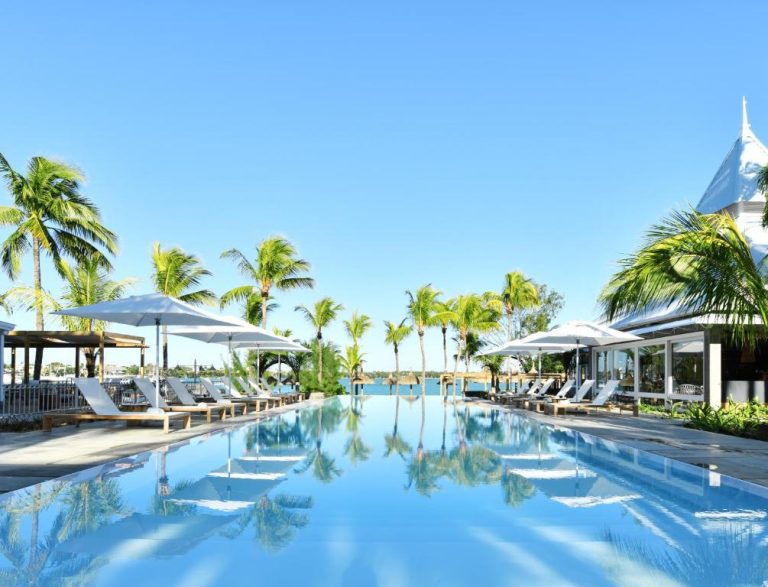 Piscina infinita con tumbonas y palmeras tropicales del Veranda Grand Baie Hotel & Spa en Mauricio