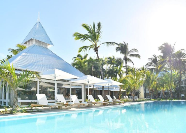 Piscina exterior con tumbonas y palmeras tropicales del Veranda Grand Baie Hotel & Spa en Mauricio
