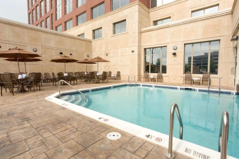 Piscina exterior con tumbonas y sombrillas del Drury Plaza Hotel Indianapolis Carmel