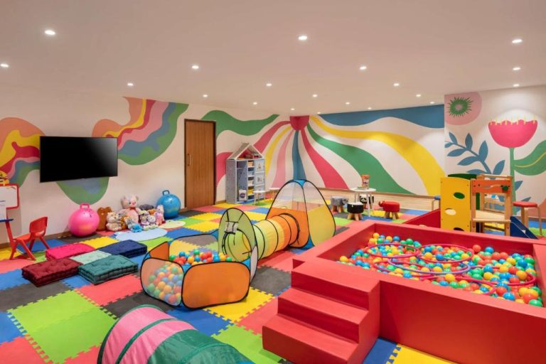 Sala de juegos infantil con piscina de bolas y toboganes de colores en Hyatt Place Goa Candolim