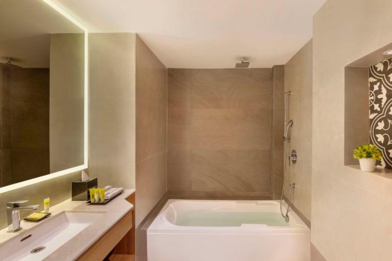 Baño moderno con bañera y ducha de lluvia en el Hyatt Place Goa Candolim
