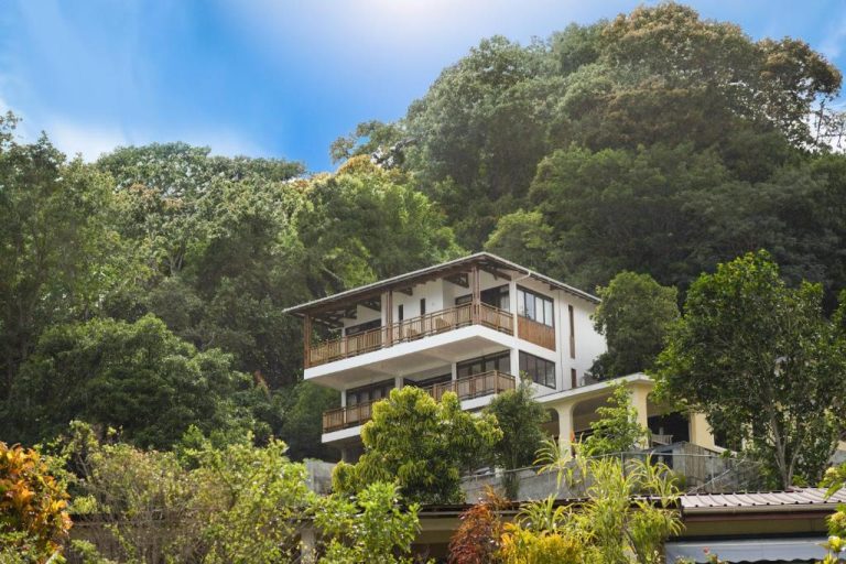 Fachada exterior de Sunbird Villas rodeada de exuberante vegetación tropical y balcones de madera