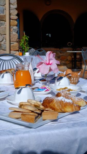 Desayuno con croissants, zumo de naranja y bollería fresca servido en la terraza exterior del Hotel Janas