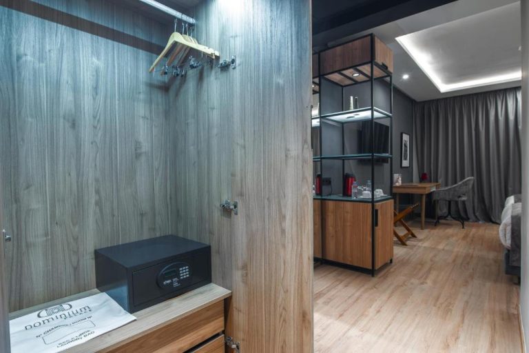 Armario con caja fuerte y perchas del Dominium Palace, con zona de minibar y escritorio al fondo
