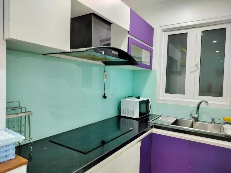 Cocina moderna equipada con armarios morados y encimera negra en Adventure Hotel