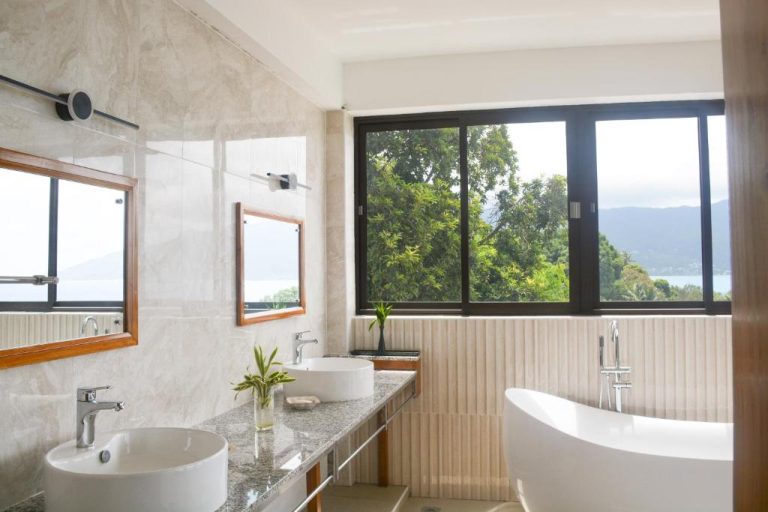Baño de lujo con bañera exenta y doble lavabo con vistas al mar en Sunbird Villas