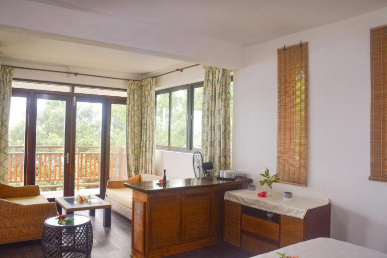 Sala de estar con terraza y vistas a la naturaleza en Sunbird Villas, decoración tropical en madera