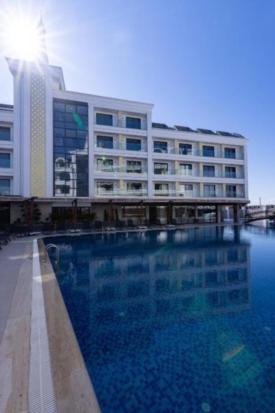 Piscina exterior de gran tamaño con vistas a la fachada principal del Belenli Resort Hotel en Turquía
