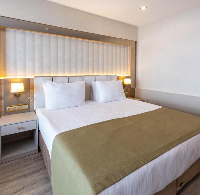 Habitación doble con cama king size y cabecero tapizado en el Belenli Resort Hotel