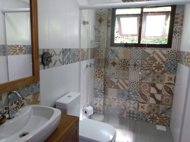 Baño privado con ducha acristalada y azulejos decorativos en Pousada Vila Guyrá