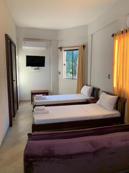 Habitación triple con tres camas individuales, televisión y ventana con vistas en Hotel Il Castello