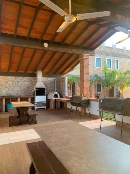 Área de parrilla y horno de leña con mesas en la terraza cubierta del Hotel Il Castello