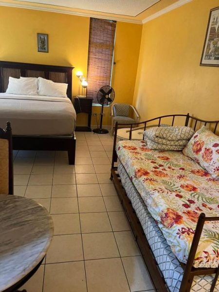 Habitación doble con cama matrimonial y cama auxiliar en Sunny Tides at Montego Bay Club Resort