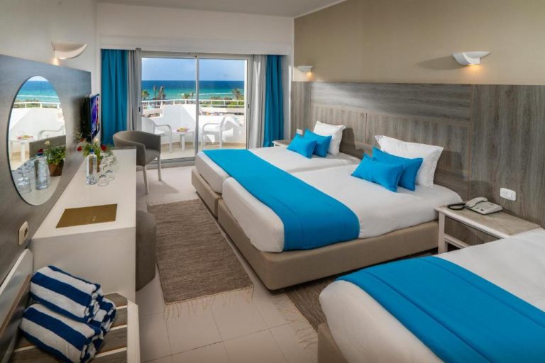 Habitación doble con camas azules y vistas al mar en el hotel Vincci Helya Beach con terraza
