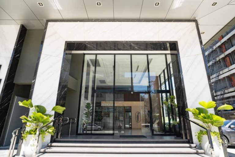 Entrada principal con fachada de mármol y puertas de cristal del Amber Hotel en Cebú, Filipinas