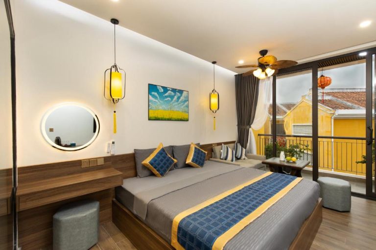 Habitación deluxe con cama doble, lámparas orientales y balcón con vistas en Hai Hội Villa Hoi An