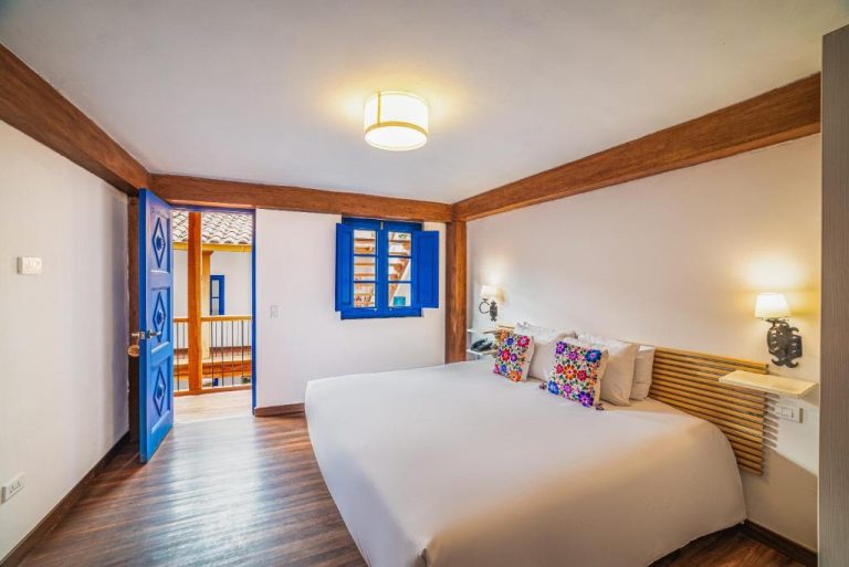 Habitación doble con puerta y ventana azules coloniales en Quinta San Blas by Ananay Hotels en Cusco