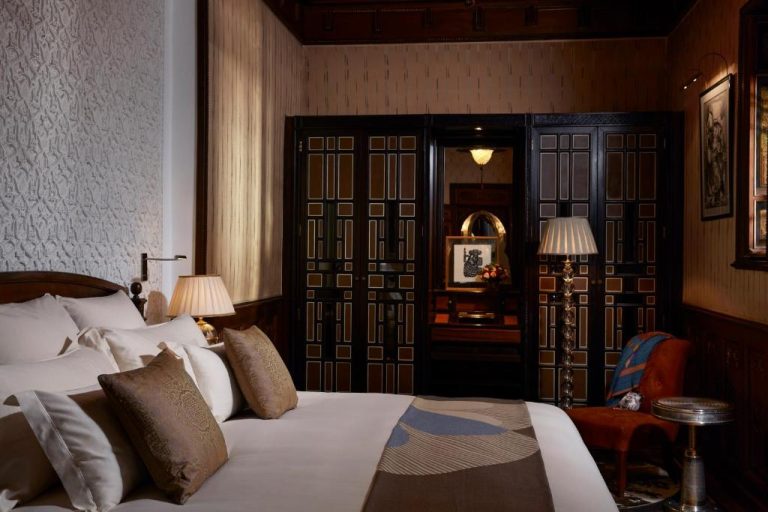 Lujosa habitación suite del Royal Mansour Marrakech con cama doble, decoración árabe y puertas talladas