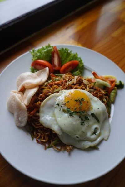 Plato de mie goreng con huevo frito y gambas en el restaurante de Balong Balong Surf Bungalows