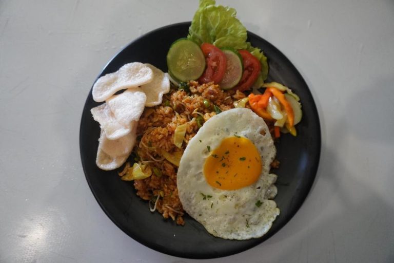 Plato de nasi goreng con huevo frito, arroz especiado y crackers en el restaurante Balong Balong Surf Bungalows