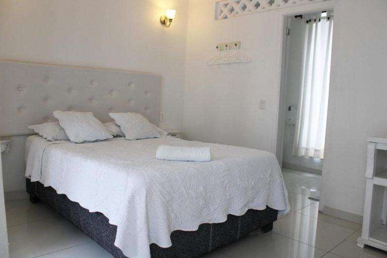 Habitación doble con cama matrimonial y decoración blanca en Hotel Casa Mara By Akel Hotels
